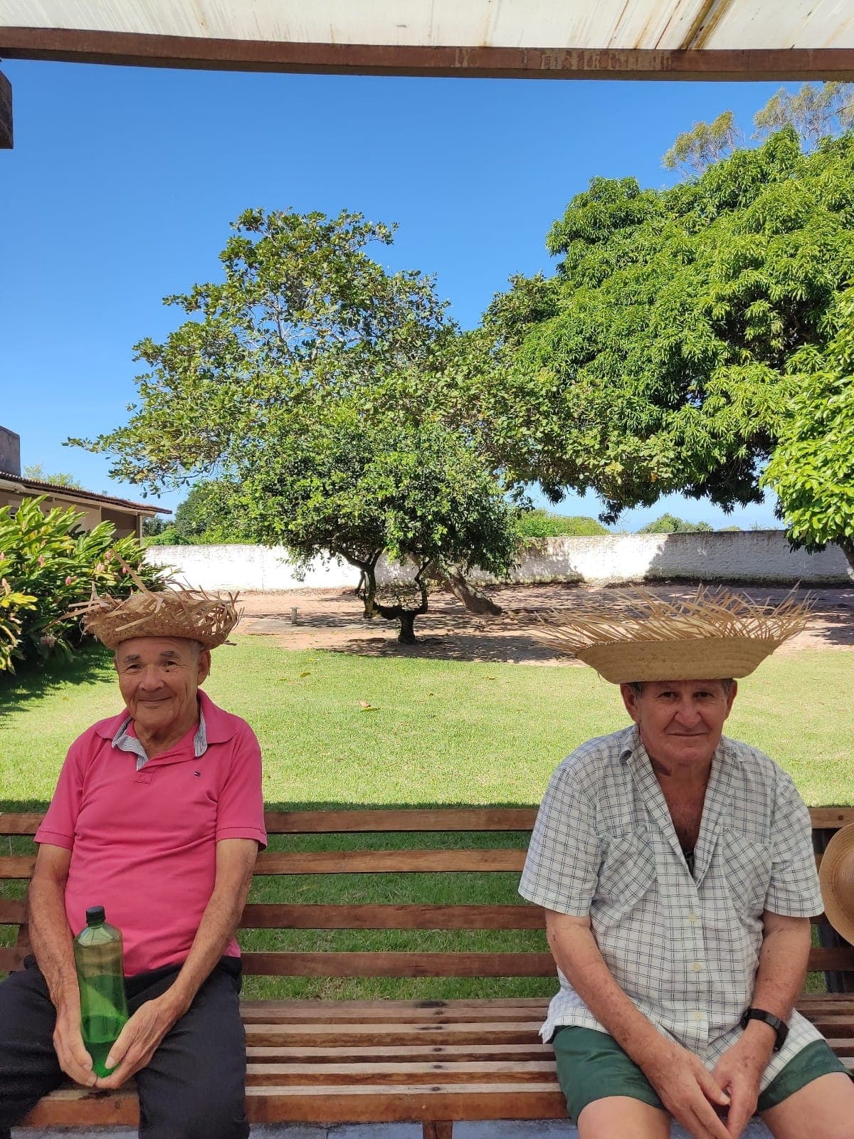 Voluntária sorrindo e auxiliando uma idosa em atividade no LEAN